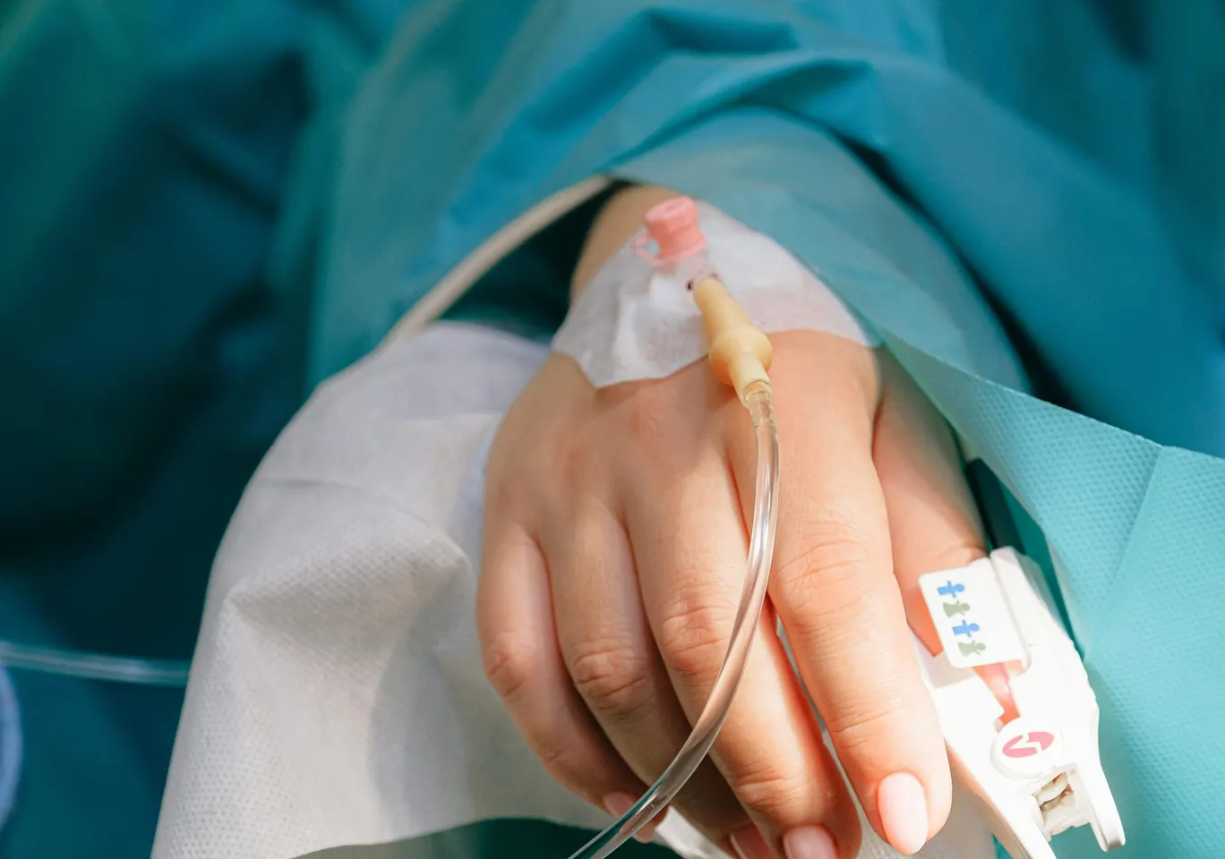 Detoks alkoholowy Gniezno: dłoń z wenflonem i pulsoksymetrem pod nadzorem